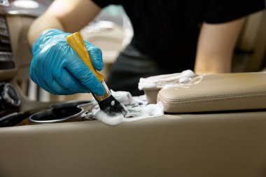 Kaliteli araba temizleme işlemi. Otomatik iç parçalar hijyenik temizleme için yumuşak alet ve köpük deterjanıyla çalışan ana eller
