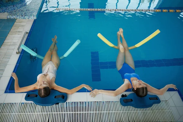 Две Женщины Делают Расслабляющие Упражнения Лапшой После Тренировки Бассейне Класс — стоковое фото