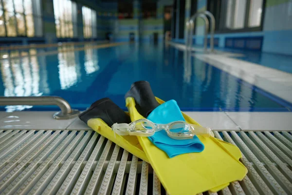 プールサイドのクローズアップでスリッパ ゴーグル 帽子のスイミングアクセサリー 水泳クラスのためのトレーニング機器 ストックフォト