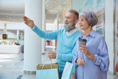 Alışveriş merkezindeki mutlu yaşlı çift Kara Cuma satışına gidiyor. Mutlu emeklilik, fiyat temizliği ve indirim kavramı