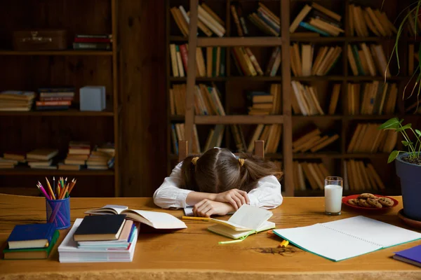 疲れた女の子の生徒は 疲れた気分で自宅の机で寝ている 研究プロセスの間に巨大な圧力 — ストック写真