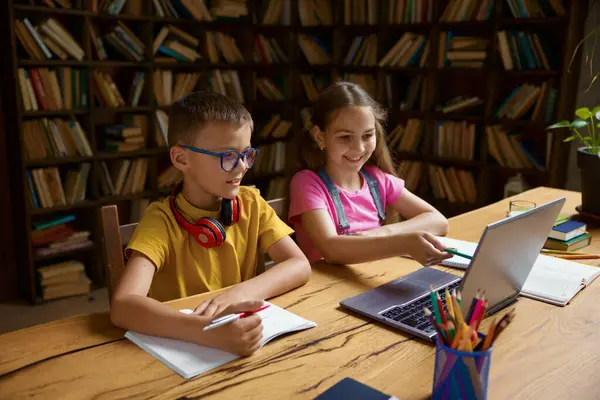 ラップトップコンピュータを使って一緒に勉強している小さな子供たち 仮想小学校で遠隔教育やEラーニングを楽しんでいるスマート兄弟 ホームスクーリング — ストック写真