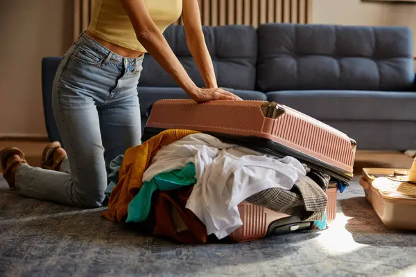 Bagaj Çantasını Fazla Kıyafetle Kapatmaya Çalışan Genç Bir Kadın Evde — Stok fotoğraf