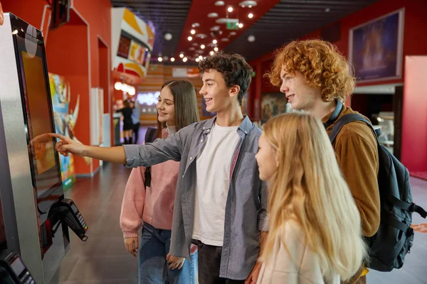 stock image Teen friends using modern self-service kiosk at shopping mall. Friends touching screen for searching information or payment in store