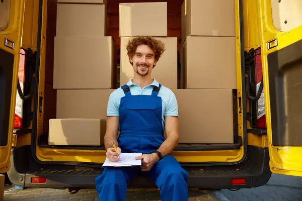 Professional male courier providing parcel management filling document for cargo delivery. Shipping service and logistics