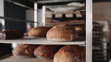 Ticari mutfakta yemek tepsisi üzerinde iştah açıcı ekmek dilimleri olan çelik raflar. Küçük işletme gıda üretimi
