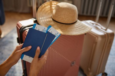 Uluslararası seyahat, yurt dışı seyahati ve tatil tatili. Pasaportu ve bileti olan bir kadın valizinin üzerinde.