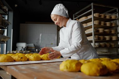 Heyecanlı fırıncı kadın fırında iyi iş çıkarmaktan gurur duyuyor. Tatlı pasta gurme servis endüstrisi
