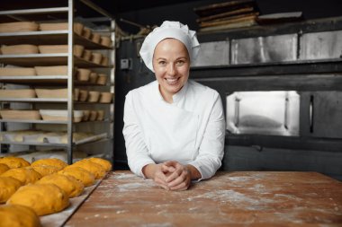 Fırında çalışmaktan gurur duyan mutlu fırıncı kadın. Tatlı pasta gurme servis endüstrisi
