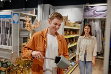 Marketten alışveriş yapan mutlu çift. Genç adam tuvalet fırçası hijyen malzemelerini seçiyor. Satış konseptiyle tatil alışverişleri