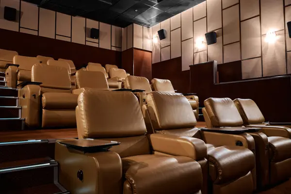 VIP place for visitors of cinema. Lounge area with leather armchair pouf seats and armrest. Amphitheatre with ottoman row