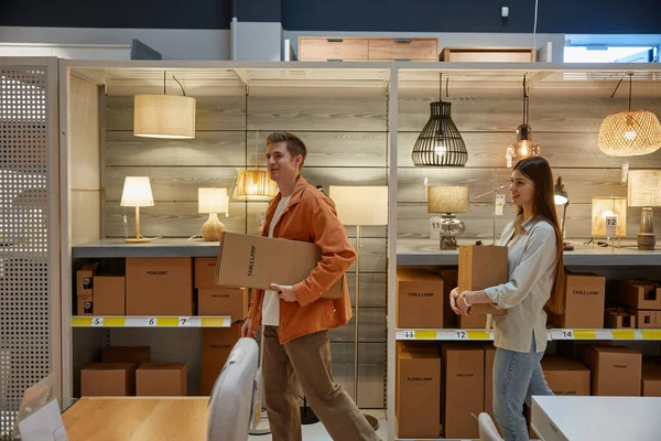 Junges Familienpaar Beim Einkaufen Modernen Lampenladen Mann Und Frau Tragen — Stockfoto