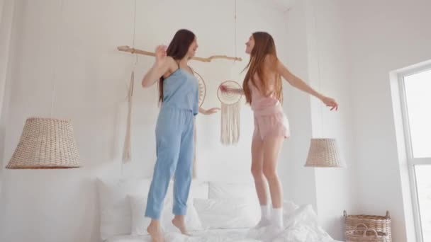 Duas Jovens Amigas Vestindo Pijama Pulando Cama Aconchegante Quarto Casa Vídeo De Stock Royalty-Free