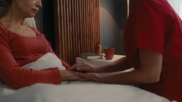 Опекун Поддерживает Пожилую Женщину Лежащую Спальне Услуги Дому Помощь Пожилым — стоковое видео
