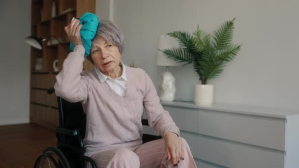 Λυπημένη Ηλικιωμένη Γυναίκα Που Κρατάει Παγοκύστη Στο Κεφάλι Και Ξεκουράζεται — Αρχείο Βίντεο