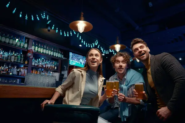 小伙子们在体育俱乐部聚会观看世界足球锦标赛 商业公司的同事们在酒吧呆在一起 喝啤酒 为足球队欢呼 免版税图库照片