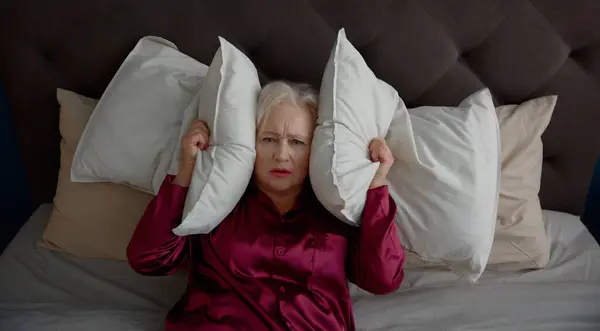 Elderly Woman Suffering Noise Trying Sleep Bed Upset Retired Female royaltyfrie gratis stockfoto