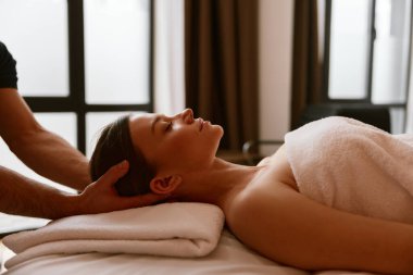 Kapalı kadın müşteri erkek eli altında rahatlıyor spa salonunda kafa masajı yapıyor. Zaman geçirme ve kendi kendine bakım kavramı