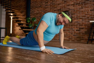 Evde şınav çeken komik ve iri yarı bir sporcu. Kilolu tombul erkek fitness egzersizi.