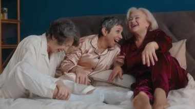 Mutlu, gevşemiş, pijama giyen, makyaj yarışması yapan yaşlı kadın arkadaşlar neşeli ve heyecanlı hissediyorlar. Kaygısız dişiler birlikte takılıyor. Yaşlılar ve güzellik
