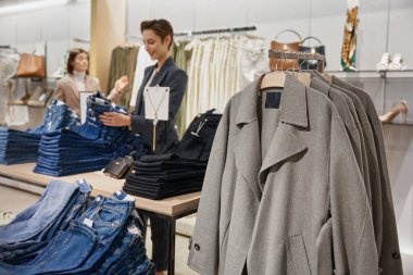 Alışveriş merkezindeki bir butik mağazasında raflarda şık kıyafetler. Giysi mağazasının içi.
