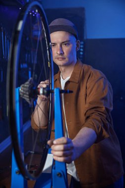 Bisiklet tekerinde çalışan teknisyen doğru kenar hizasını kontrol ediyor. Bisiklet tamir atölyesi konsepti