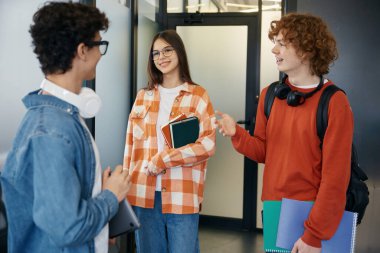 Bazı genç işçiler işten sonra konuşuyor. Ofiste sohbet eden gülümseyen gençler.