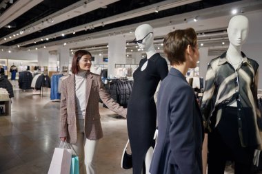 Alışveriş turizmine katılan iki zarif bayan arkadaş. Kadın tüketiciler hafta sonları alışveriş merkezinde birlikte vakit geçiriyorlar.