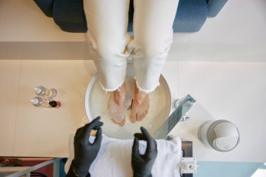 Güzellik salonunda pedikür işleminden önce bacaklar için seramik banyo kasesi. Profesyonel ayak hastalıkları bürosunu ziyaret ediyorum.