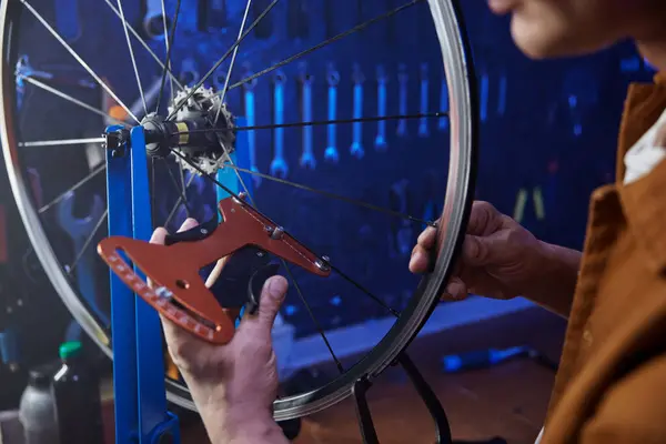 stock image Bike mechanic doing tensioning and alignment of bicycle spokes using special tools closeup view. Sport bike vehicle repairing and maintenance concept