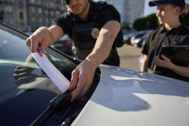 Devriye polisi ve devriye memuru yanlış yere park ettiği için ceza kesiyor. Trafik kurallarının ihlalinin önlenmesi