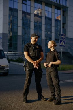 Dışarıdaki polis karakolunda duran güler yüzlü devriye memurlarına hoş bir sohbet.