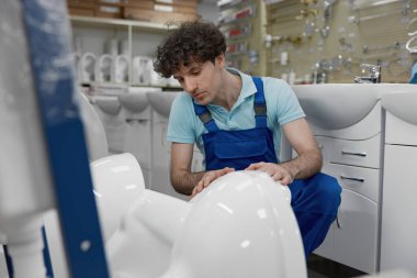 Tesisatçı yeni seramik klozeti seçiyor karar veriyor ve tesisat dükkanından doğru olanı seçiyor.