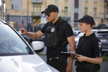 Devriye polisi ve devriye polisi park ihlalinden trafik cezası yazıyor. Sokak güvenliği ekibi iş başında.