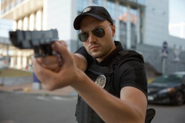 Şehir caddesinde silahlı bir polis memurunun portresi.