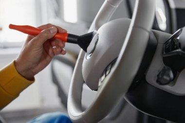 Yakından erkek otomatik sektirme işçisi el temizleme direksiyonu deterjan köpüğü ve fırçayla. Araba temizleme ve temizlik servisi