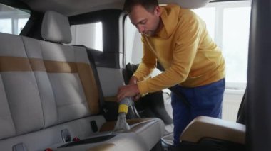 Arabanın içini, ulaşılması zor yerlere ulaşmak için özel hortum kullanarak elektrikli süpürgeyle temizlemek. Otomatik temizlik ve temizlik servisi