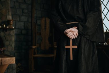 Yakın çekim görüntüsü rahiplerin elinde altın haçla kesilmiş. Ortaçağ keşişi dua kavramı