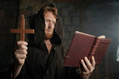 Rahip haç tutuyor, İncil okuyor, dua ediyor ve şeytan çıkarma ayini yapıyor.