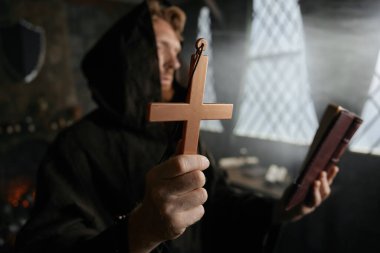 Rahip haç tutuyor, İncil okuyor, dua ediyor ve şeytan çıkarma ayini yapıyor.