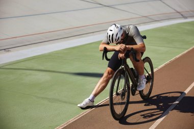 Yorgun bisikletçi sporcu sıkı bisiklet eğitiminden sonra yarış pistinde durdu. Profesyonel spor ve hobi eğlence takip konsepti