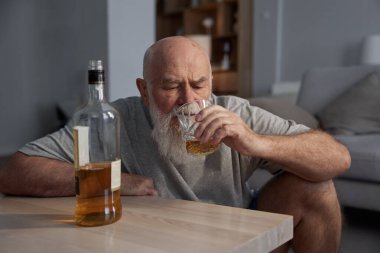 Emekli son sınıf öğrencisi evde tek başına oturmuş alkol içiyor. İçki zararlı bir alışkanlık ve alkol bağımlılığı