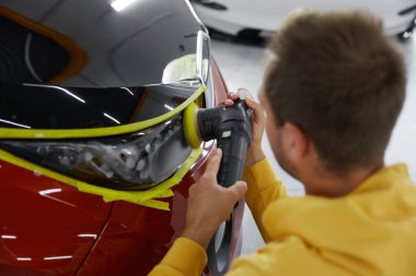 Servis teknisyenleri araba tamirhanesinde çalışırken özel enjektörlü manuel güç döndürme makinesi kullanıyor.