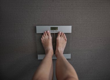 Kadın ayaklarının ölçekli görüntüsü anoreksik vücut ağırlığını gösteriyor. Aşırı beslenme sorunu, anoreksi sinirvosa gelişimi nedeniyle kütlenin kontrol edilmesi