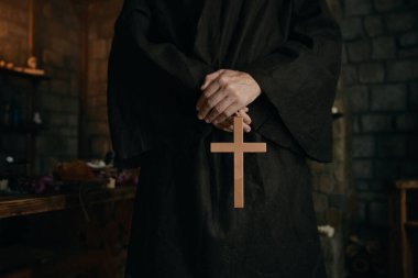 Yakın çekim görüntüsü rahiplerin elinde altın haçla kesilmiş. Ortaçağ keşişi dua kavramı