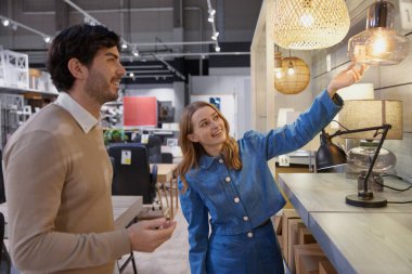 Modern ev dekorasyonu için şık bir mağazada alışveriş deneyimi yaşayan bir çift.