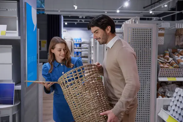 Renkli perakende raflarının arasından şık ve güzel örülmüş bir sepet seçen erkek ve kadın.