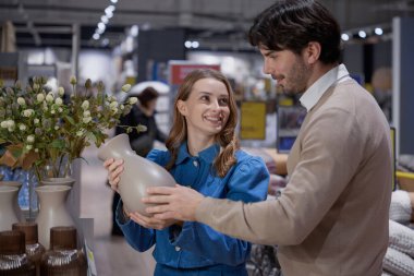 Bugün şık bir ev eşyası dükkanından güzel dekoratif bir vazo seçen çift.