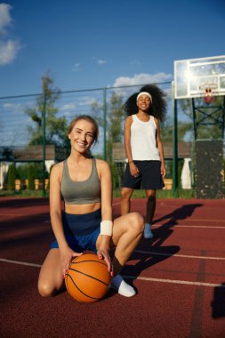 Hoş, çok kültürlü bayan basketbolcu izlenimini paylaşıyor. Açık hava sahasında maç üstüne dinleniyor.