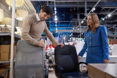 Genç bir çift ideal bir ofis koltuğu seçiyor. Konfor ve estetik stili sorunsuz bir şekilde dengeliyor.